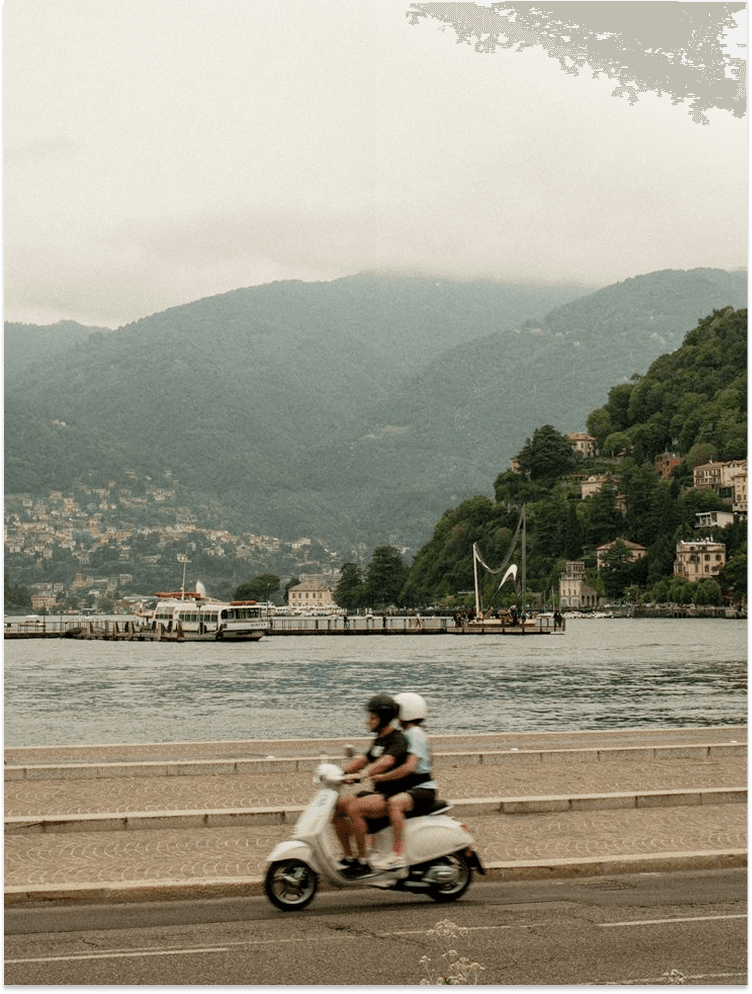 A couple riding a scooter along the Bay of Kotor